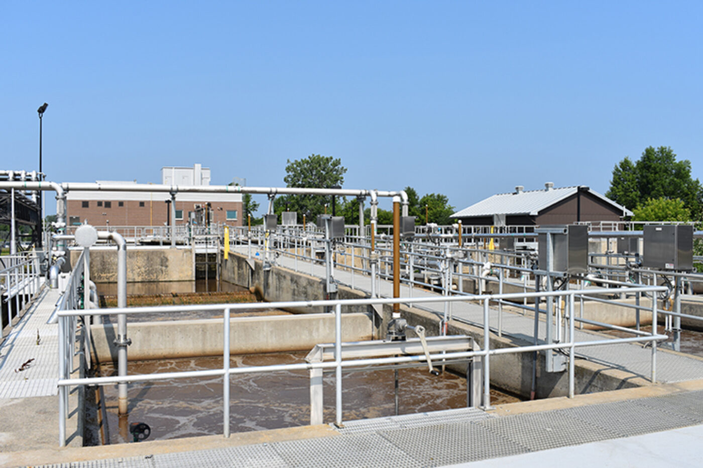 Photo of the Hawkesbury wastewater treatment plant, with its multiple concrete basins, grates and pipes.