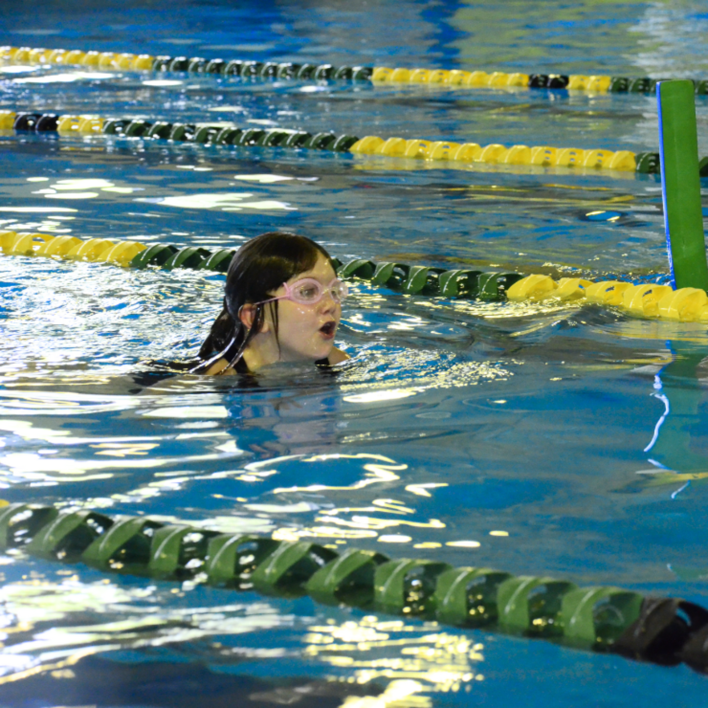 Photo of a child swimming in a pool corridor.