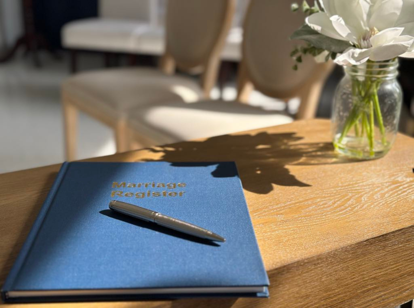 A mariage register and pencil on a table.