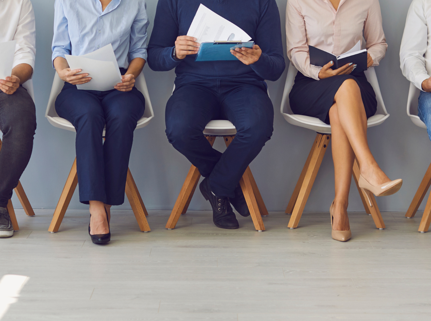 Generic photo of colleagues sitting on chairs holding documents