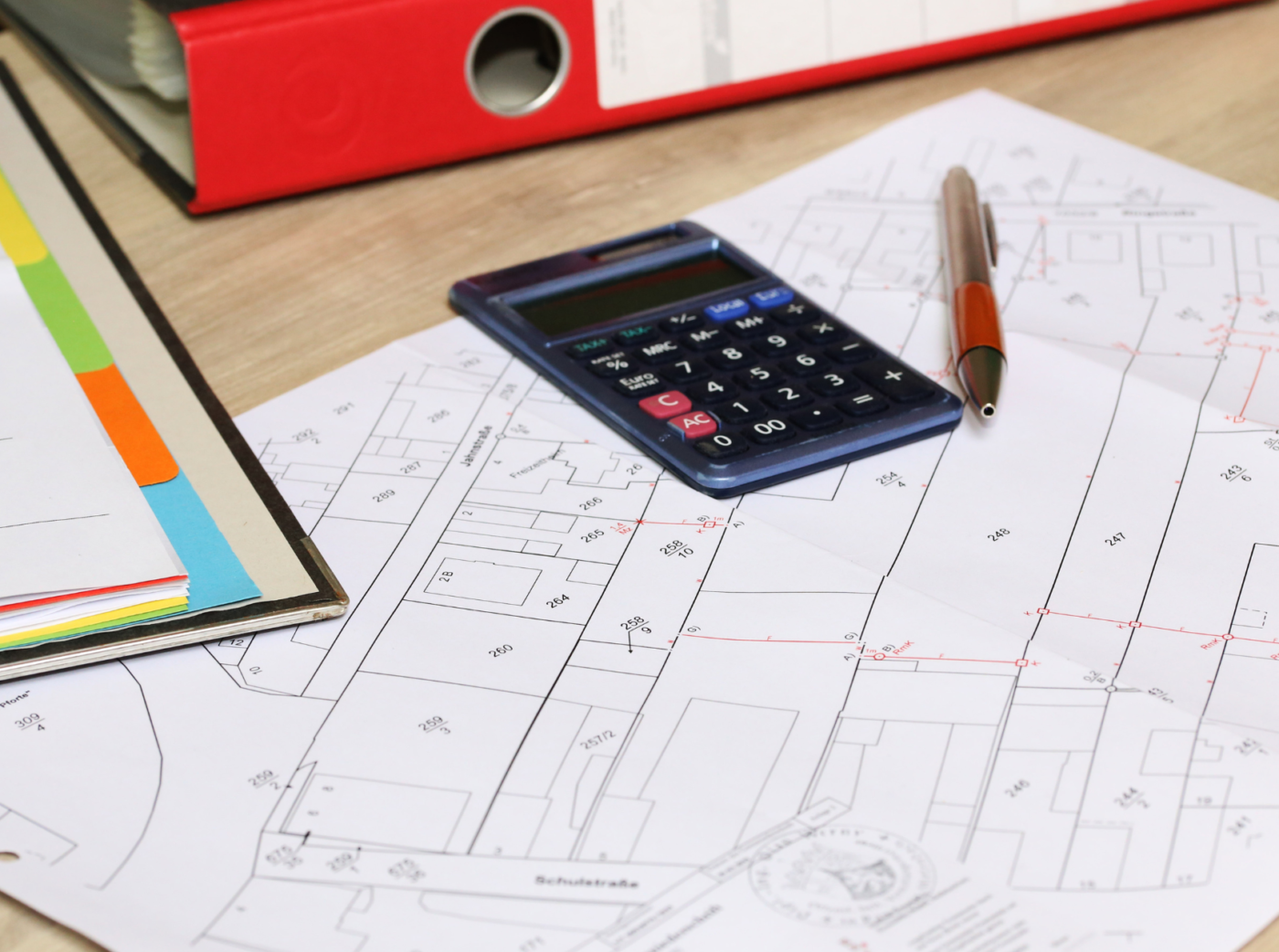 Calculator, pencil and binders on a cadastral map