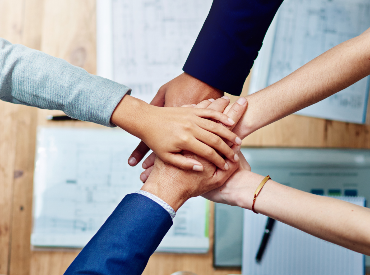 Photo of several hands stacked on top of each other.
