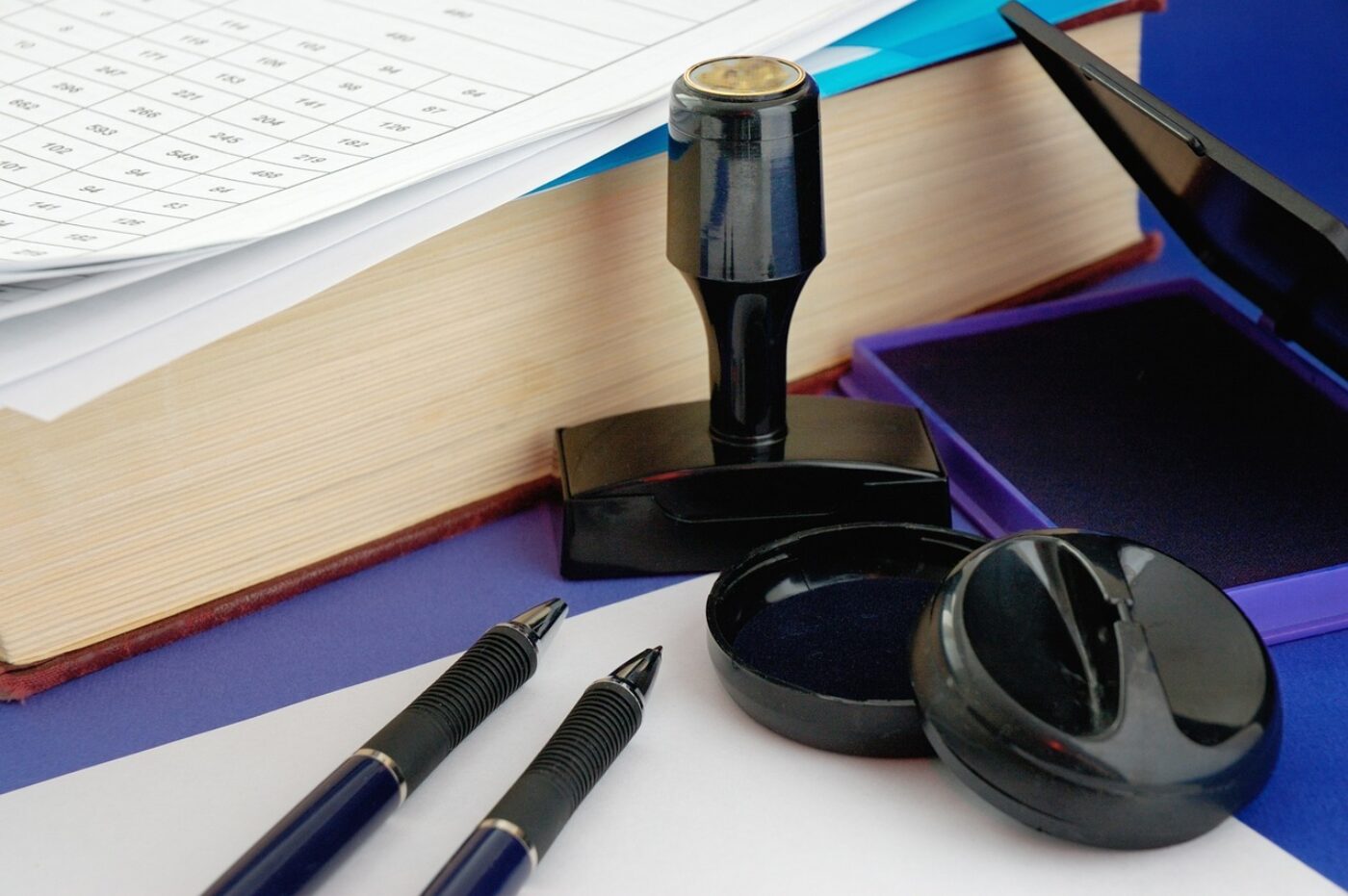 Close-up of documents, pencils and stamps.