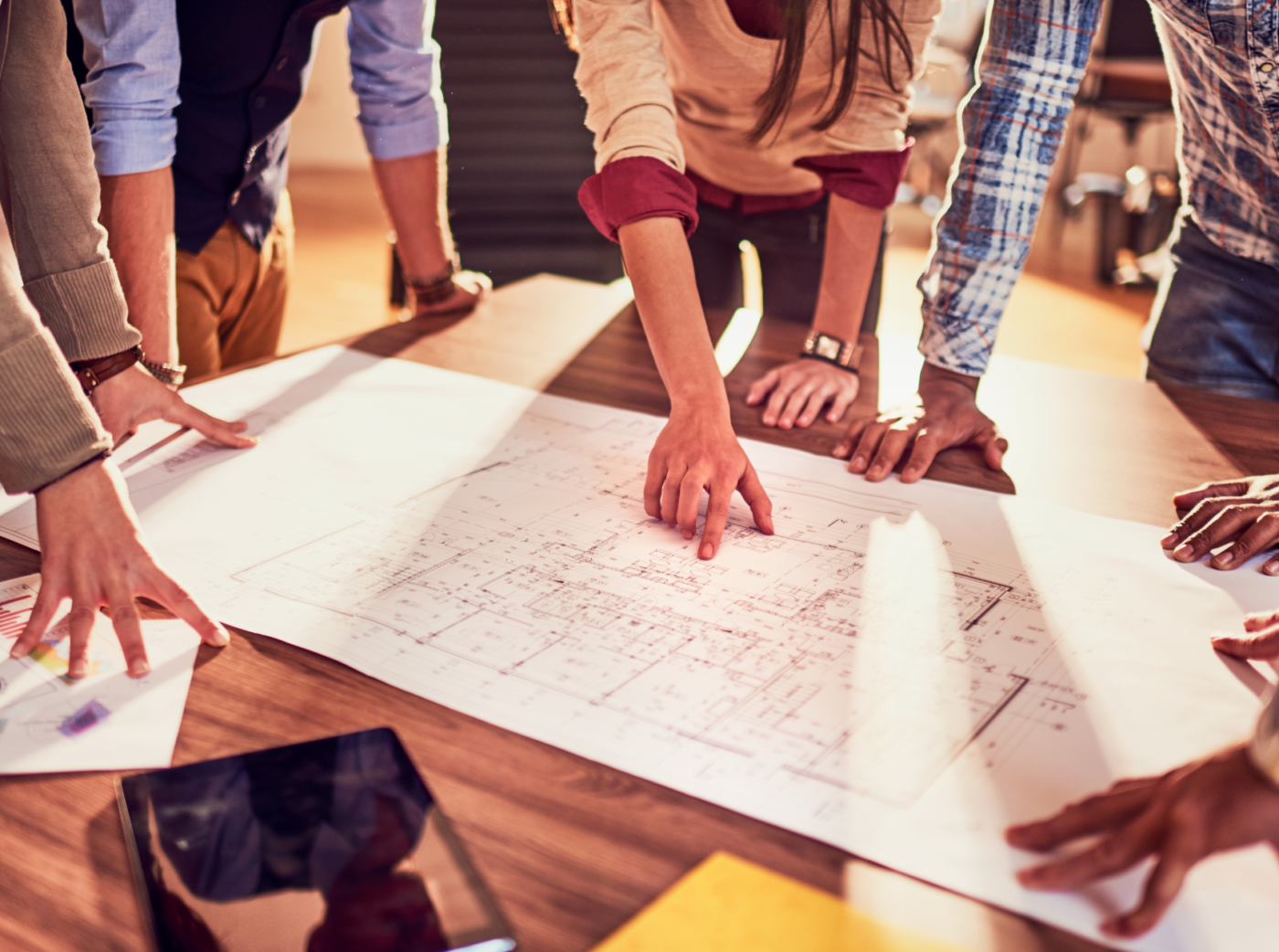Close-up of a group of people gathered around a building plan