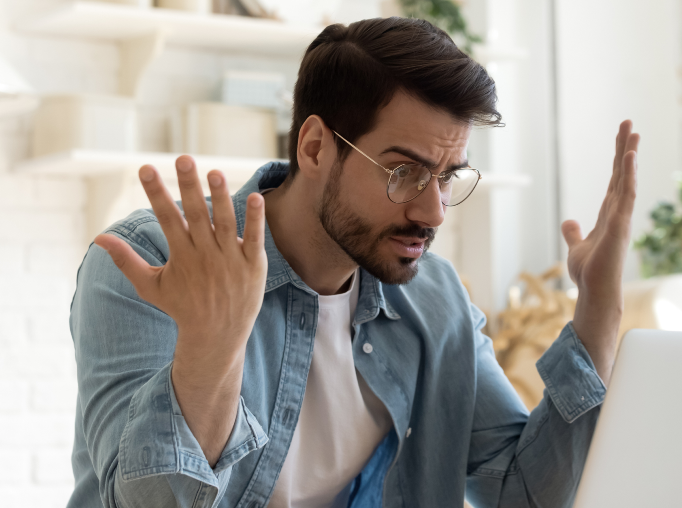 Generic photo of a person using a laptop with a confused look on his face.