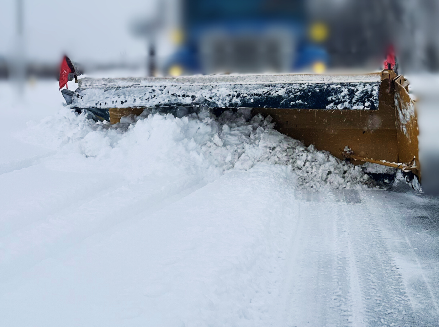 Close-up of a snow removal truck shovel in the middle of a snow clearing operation.